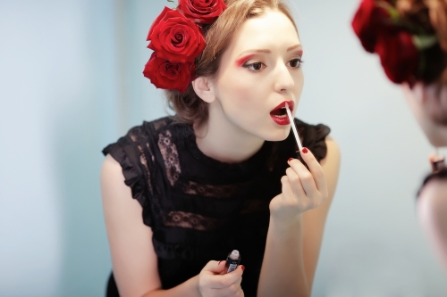 Woman applying lipstick. 